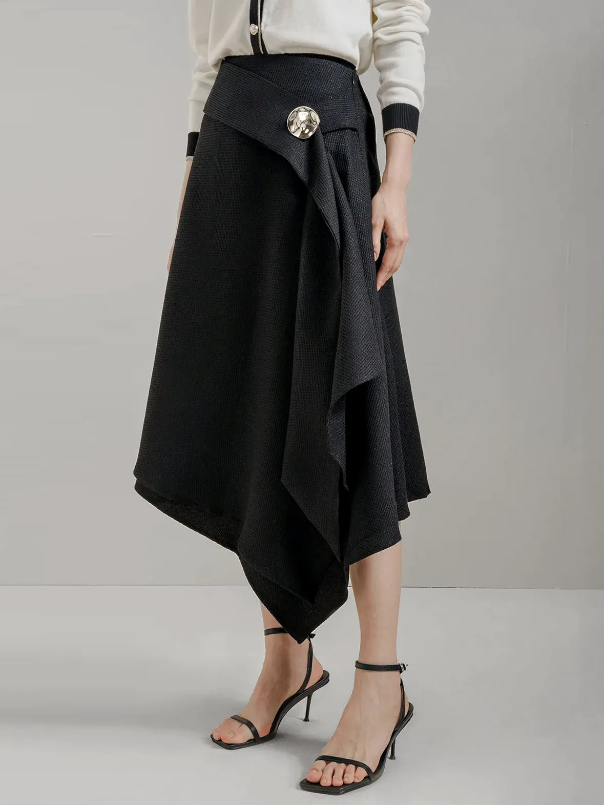 Black midi skirt with geometric cut and side metal buttons