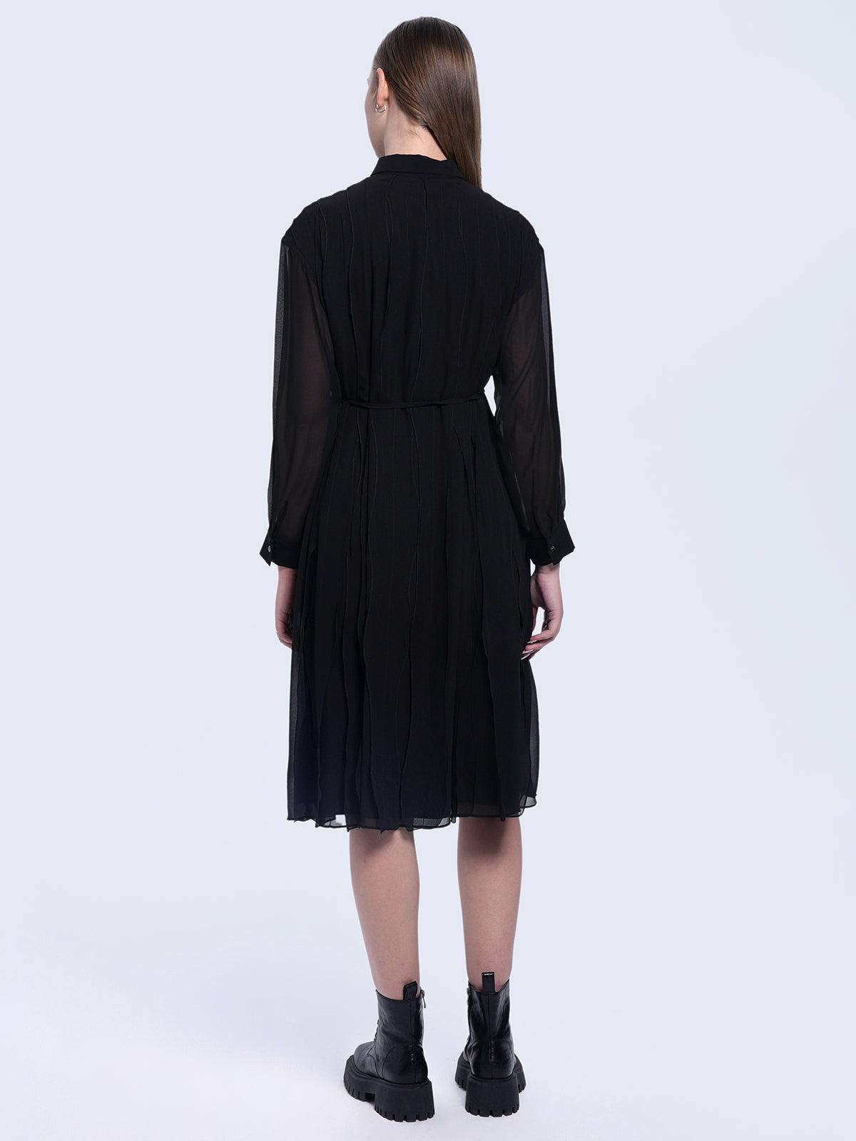 S·DEER black pleated shirt dress, emphasizing the minimalist design and pleats that provide movement and texture, ideal for versatile styling